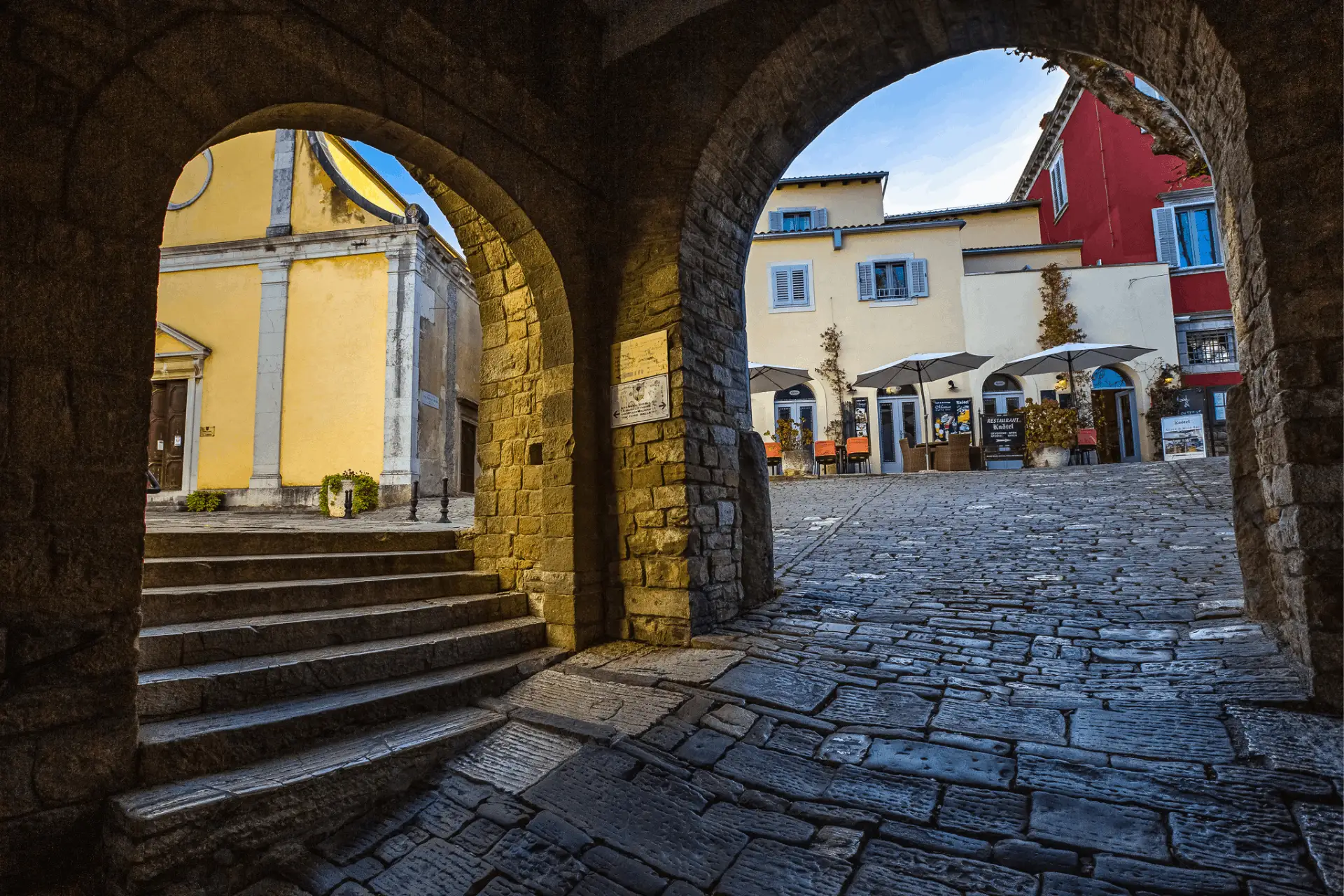 view on the town square in Motovun with cafes, souvenir shops and a church