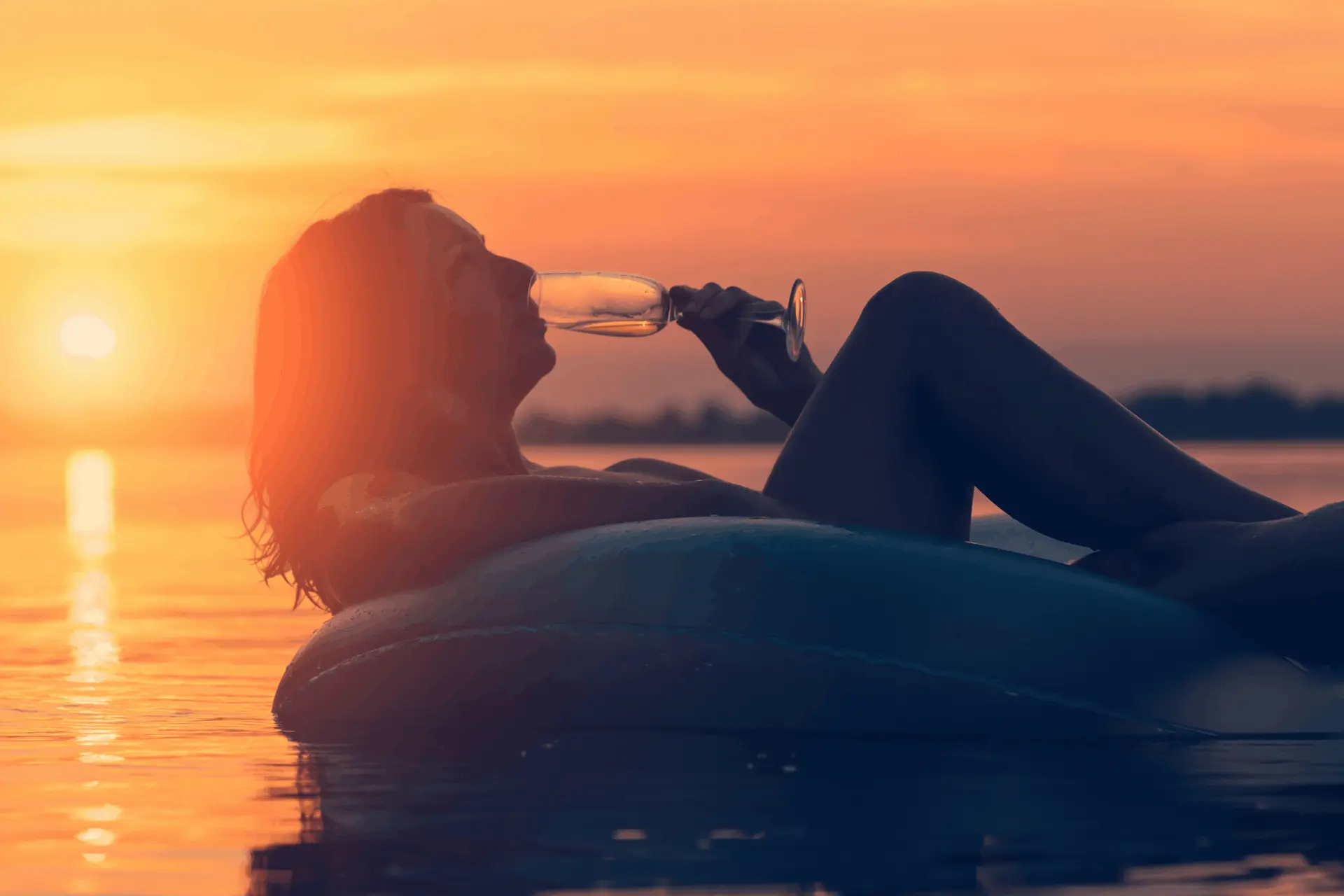 woman enjoying drinking wine, floating on a mattress in the pool activities in istria