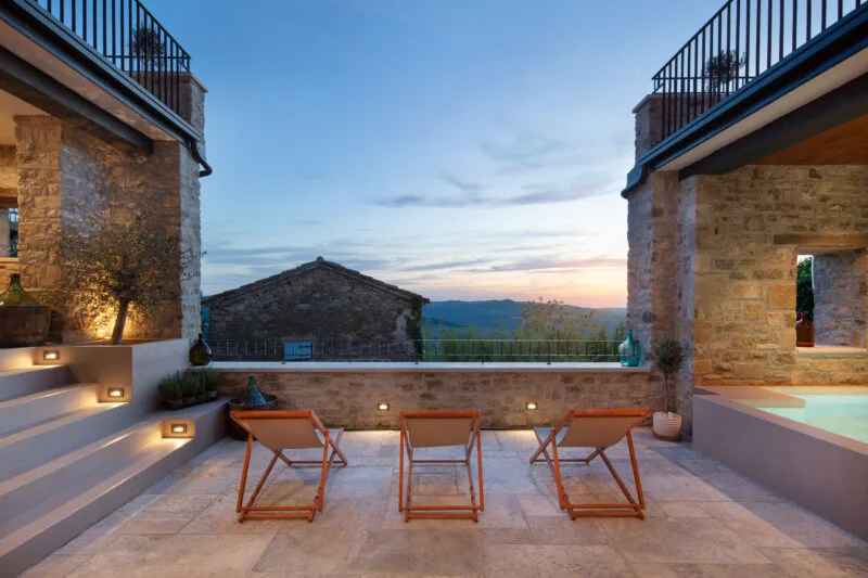 luxurious plateu of Villa Motovun with three lounge chairs beside a pool