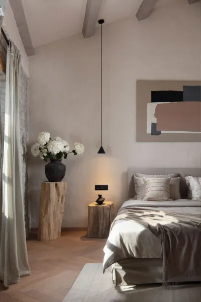 bedroom in Luxury villa in Motovun with high ceiling, white walls, artwork on the walls, hardwood flooring and a large bed